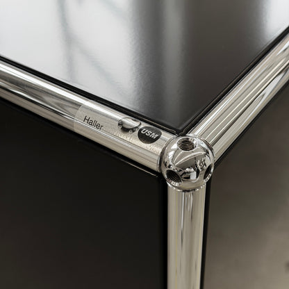 USM Haller Sideboard 2x2 in Schwarz mit glänzender Oberfläche und verchromten Eckverbindern.