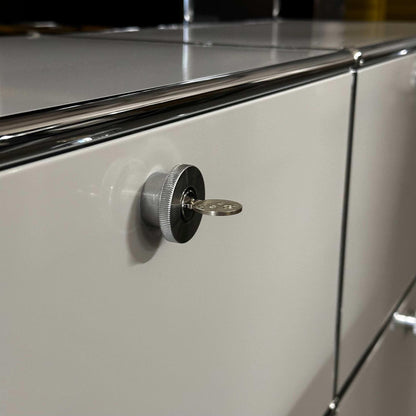 Close-up of light grey USM Haller Sideboard with locking key and chrome accents
