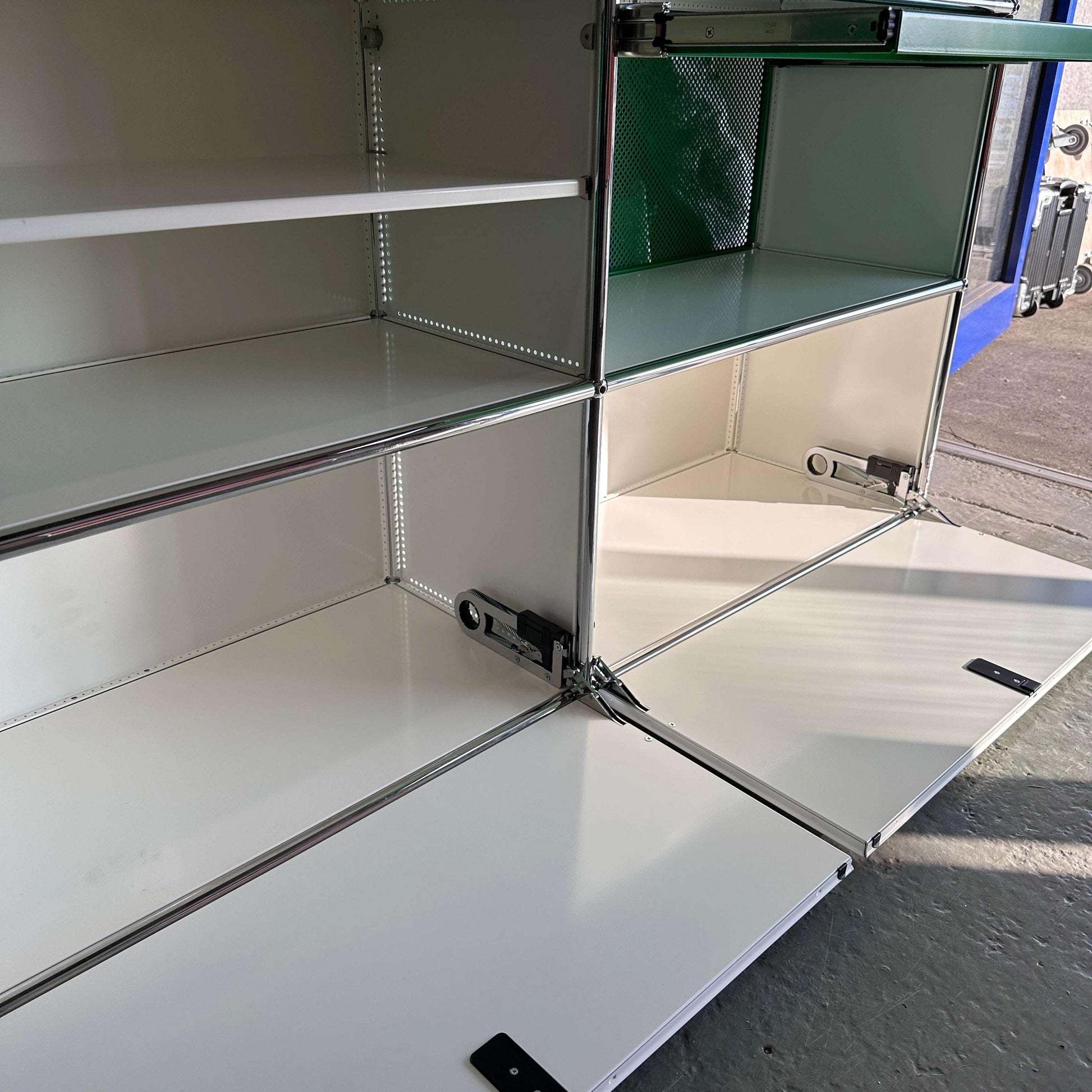 USM Haller Sideboard 3x3 weiß grün mit geöffneter Klappe und integrierten Pflanzeinsätzen
