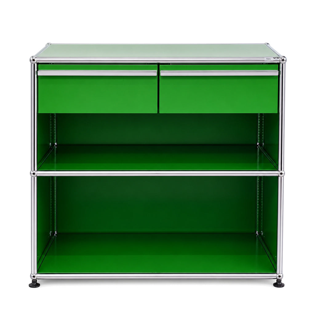 Grünes USM Haller Sideboard mit zwei Schubladen und zwei offenen Regalfächern im klassischen Stahlrohr-Design.