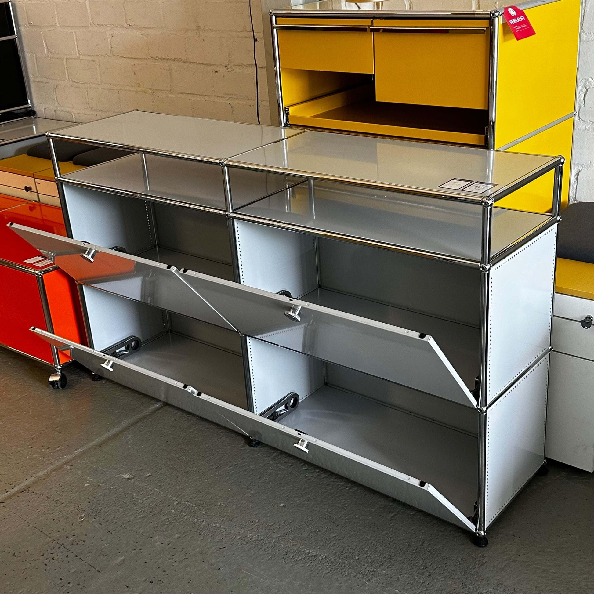 USM Haller Sideboard in light gray with two rows of two drop-down compartments and glass top, measuring 151x88x37cm