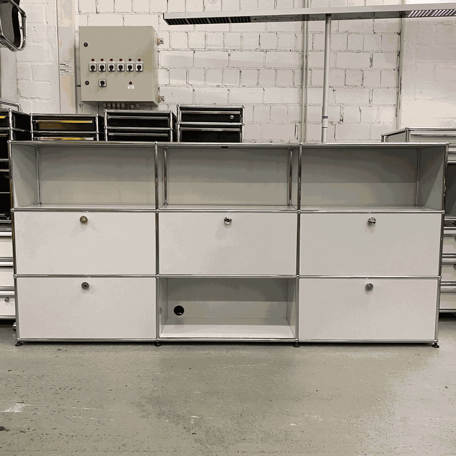 USM Haller sideboard in light gray with 4 flap doors, 1 drawer, and cable outlets, measuring 228x109x38 cm