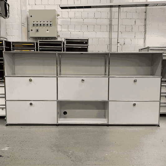 USM Haller sideboard in light gray with 4 flap doors, 1 drawer, and cable outlets, measuring 228x109x38 cm