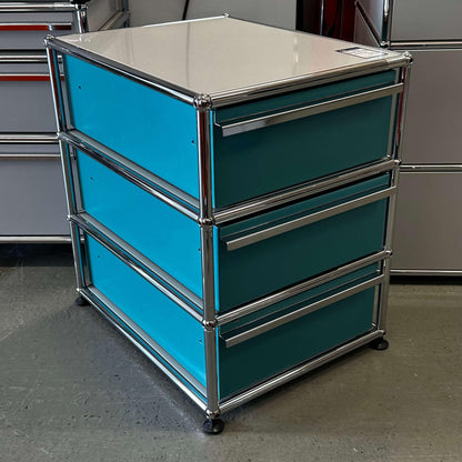 USM Haller Standcontainer with three turquoise drawers and light gray top panel in metal frame