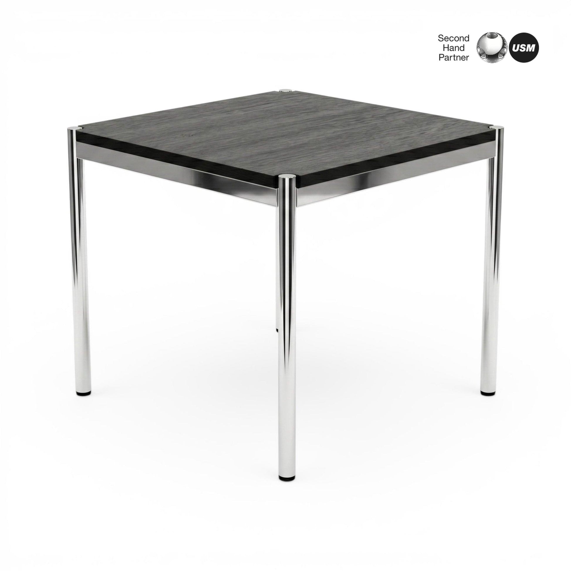 USM Haller Tisch 70x70cm, schwarze Eichenplatte mit sichtbarer Maserung, auf glänzenden Chrombeinen.