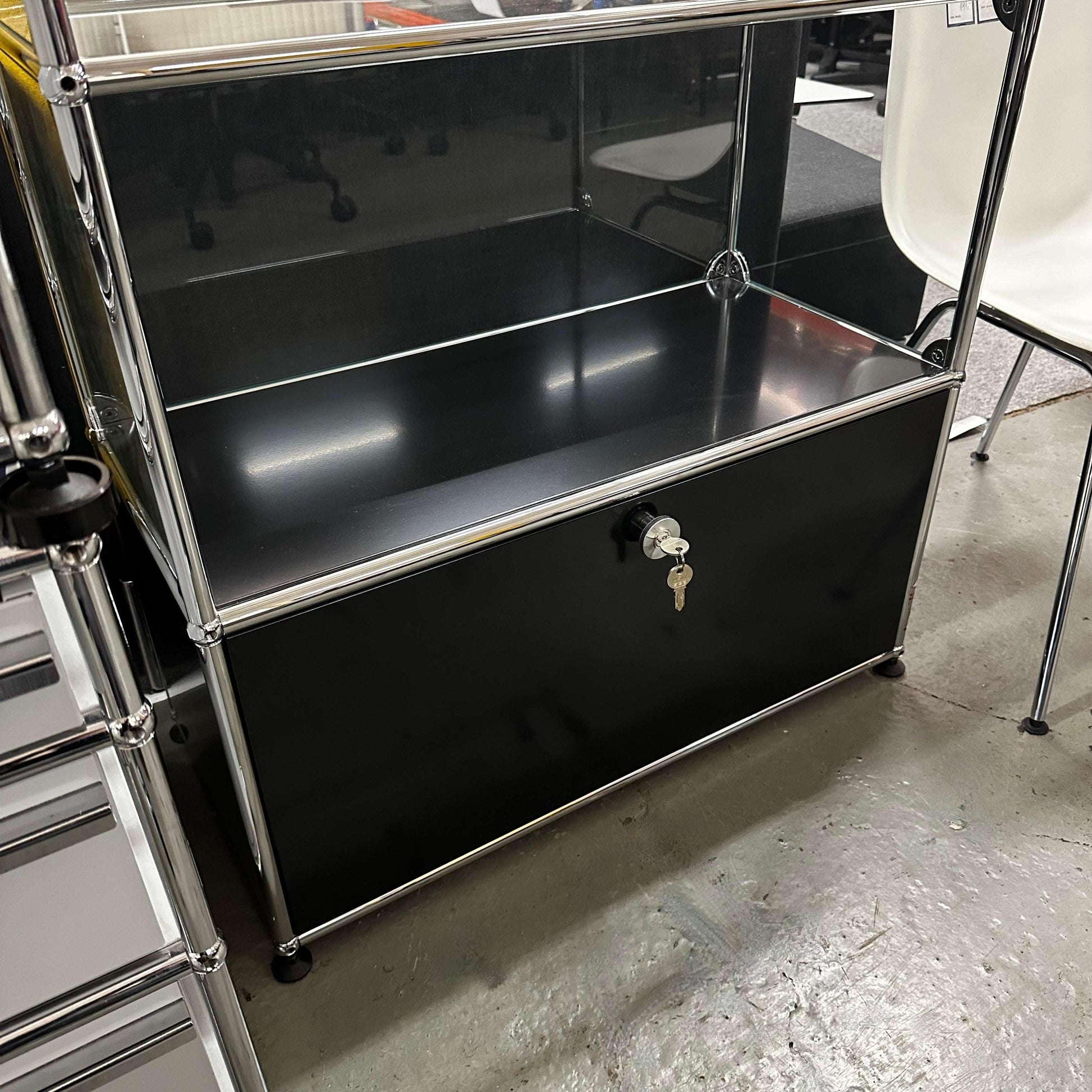USM Haller black display cabinet with glass panels and lockable flip door