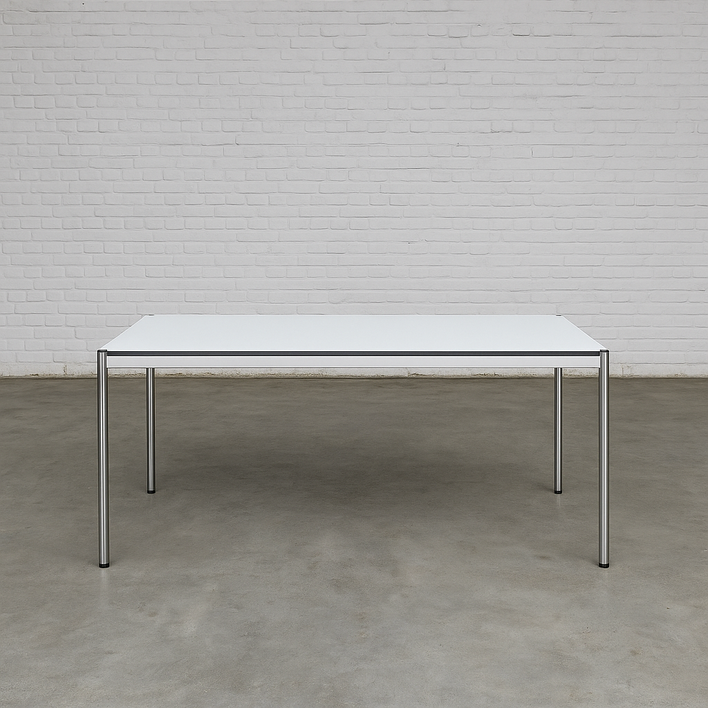 USM Haller Tisch 200x100cm perlgrau weiß mit Stahlgestell und optionalem Zubehör vor weißer Ziegelwand