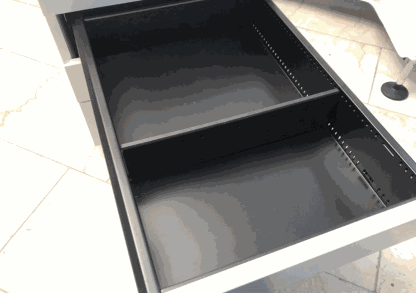 Black open drawer of VS Rollcontainer storage unit with combination lock on tiled floor