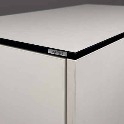 weißer Vario Apothekerschrank mit schwarzer Kante und Vario-Logo nahaufnahme Ecke