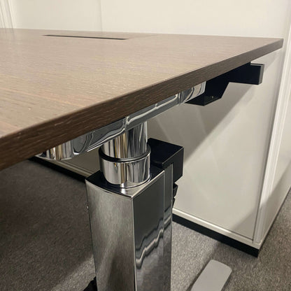 Close-up of Vario Change 200x100cm electric height-adjustable desk with smoked oak tabletop and chrome T-foot frame
