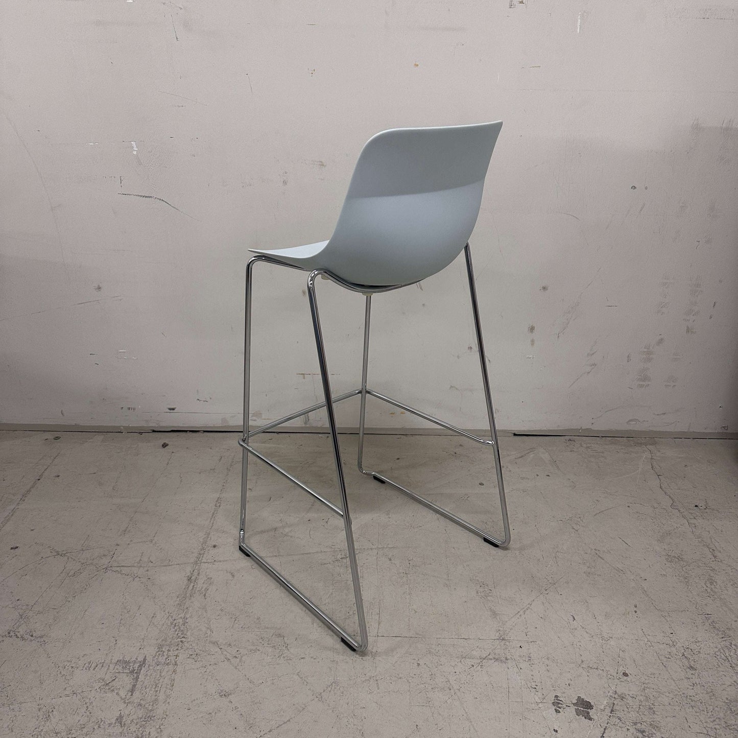 Viasit Solix Barhocker aus hellblauem Kunststoff mit verchromtem Metallgestell vor grauer Wand