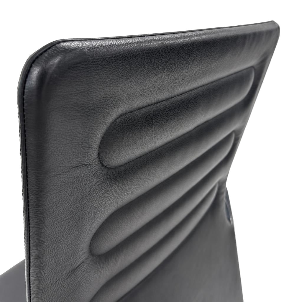 Vitra AC 4 Meet Bürostuhl mit hochwertigem, schwarzem Lederbezug und markanter horizontaler Polsterung der Rückenlehne.