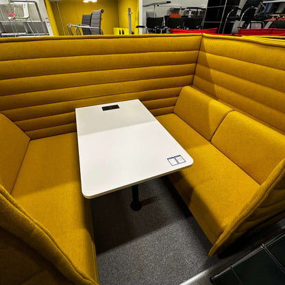 Vitra Alcove Cabin highback seating with integrated white worktable in mustard yellow upholstery