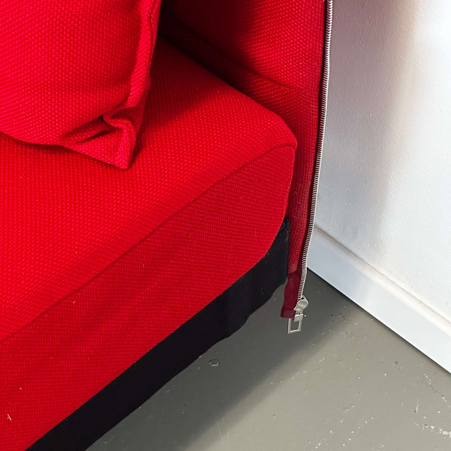 Close-up of red Vitra Alcove Ecke expandable corner sofa with textured fabric and zipper detail
