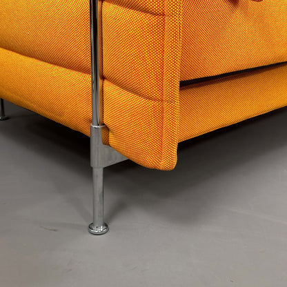 Detailaufnahme des orangen Vitra Alcove Highback Loveseat mit chromfarbenem Stahlrohrgestell und robustem, recyceltem Polyesterstoff-Bezug
