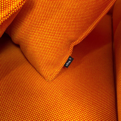 Nahaufnahme von oranger Vitra Alcove Highback Loveseat Stoffoberfläche mit Vitra-Logo-Tag