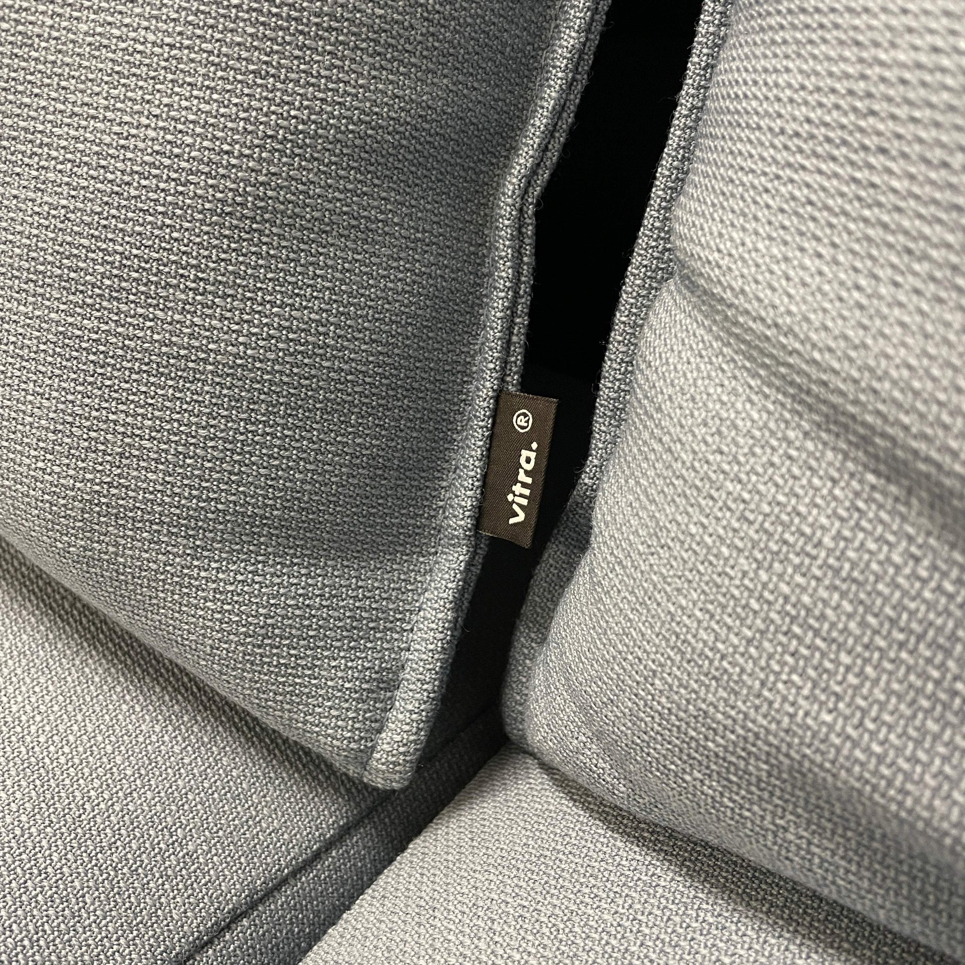 Nahaufnahme des petrolfarbenen Vitra Alcove Lowback 3-Sitzer Sofas mit robustem Stoffbezug und sichtbarem Vitra-Label