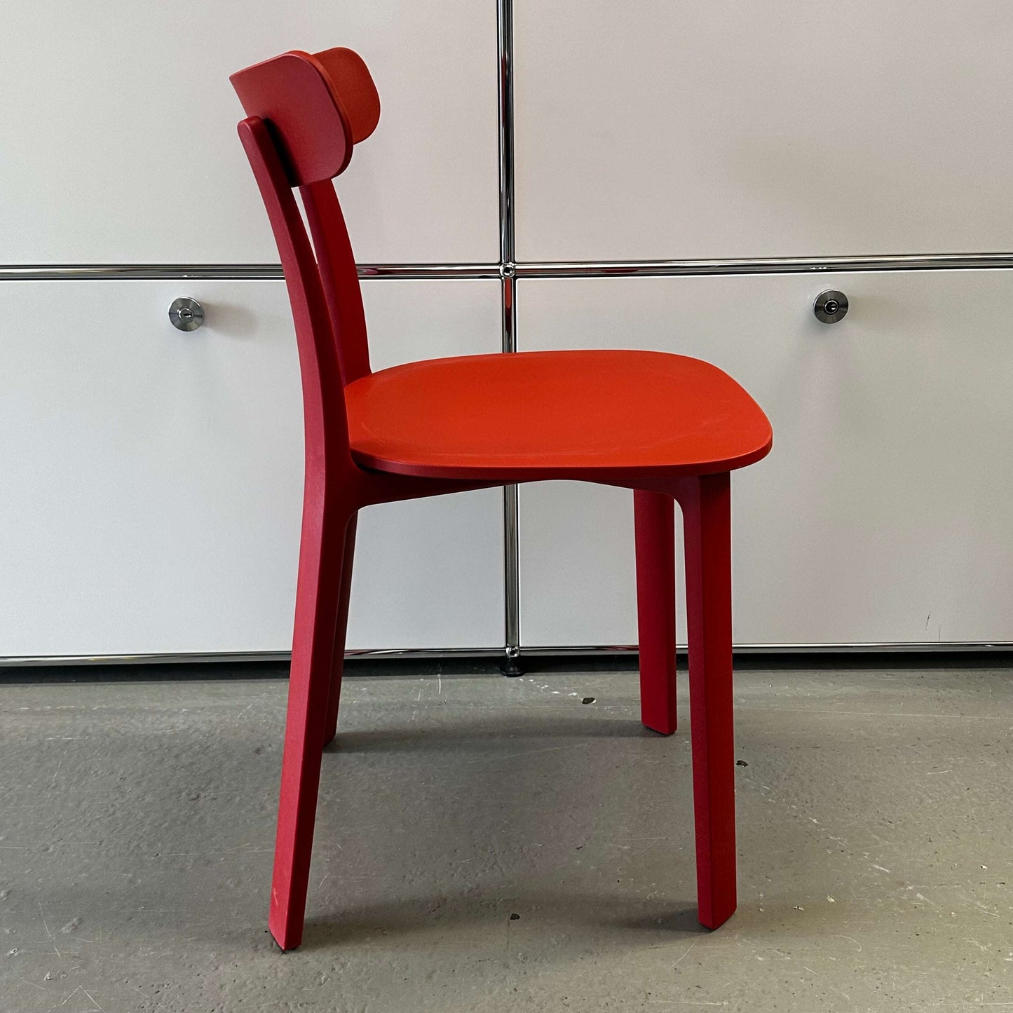 Vitra All Plastic Chair in brick red with minimalist design and ergonomic shape suitable for indoor and outdoor use