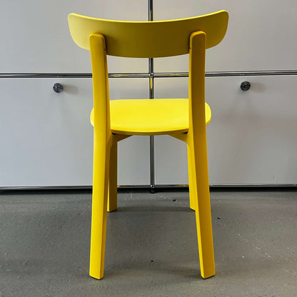 Back view of Vitra All Plastic Chair in bright Butterblume yellow, modern minimalist design for indoor and outdoor use