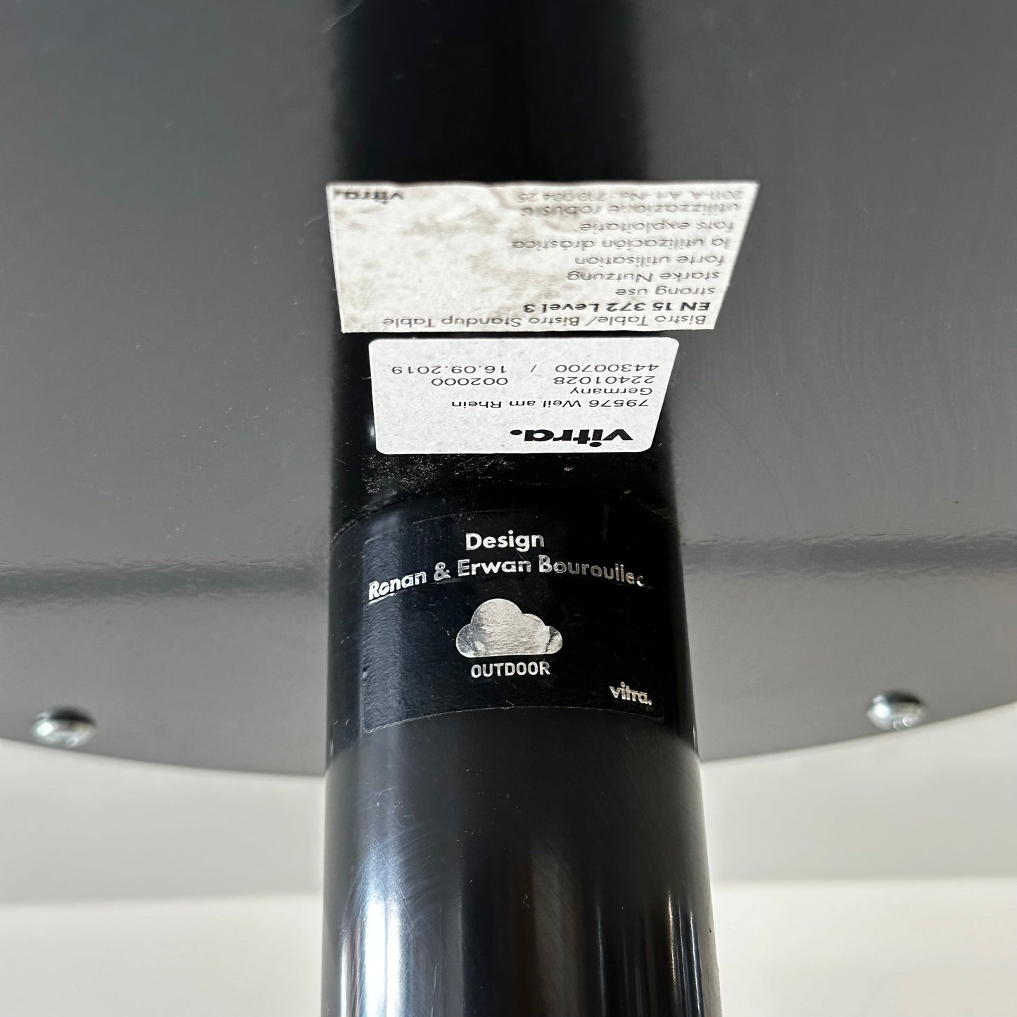 Close-up of Vitra Bistro Table black metal leg with designer label by Ronan & Erwan Bouroullec, suitable for outdoor use