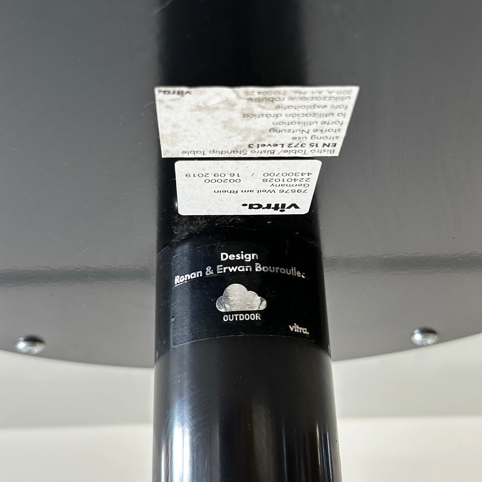 Close-up of Vitra Bistro Table black metal leg with designer label by Ronan & Erwan Bouroullec, suitable for outdoor use