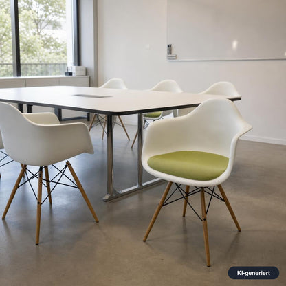 Vitra Eames DAW Armlehnstuhl mit weißer Sitzschale, grünem Polster und Ahornholz-Gestell in einem modernen Büro.