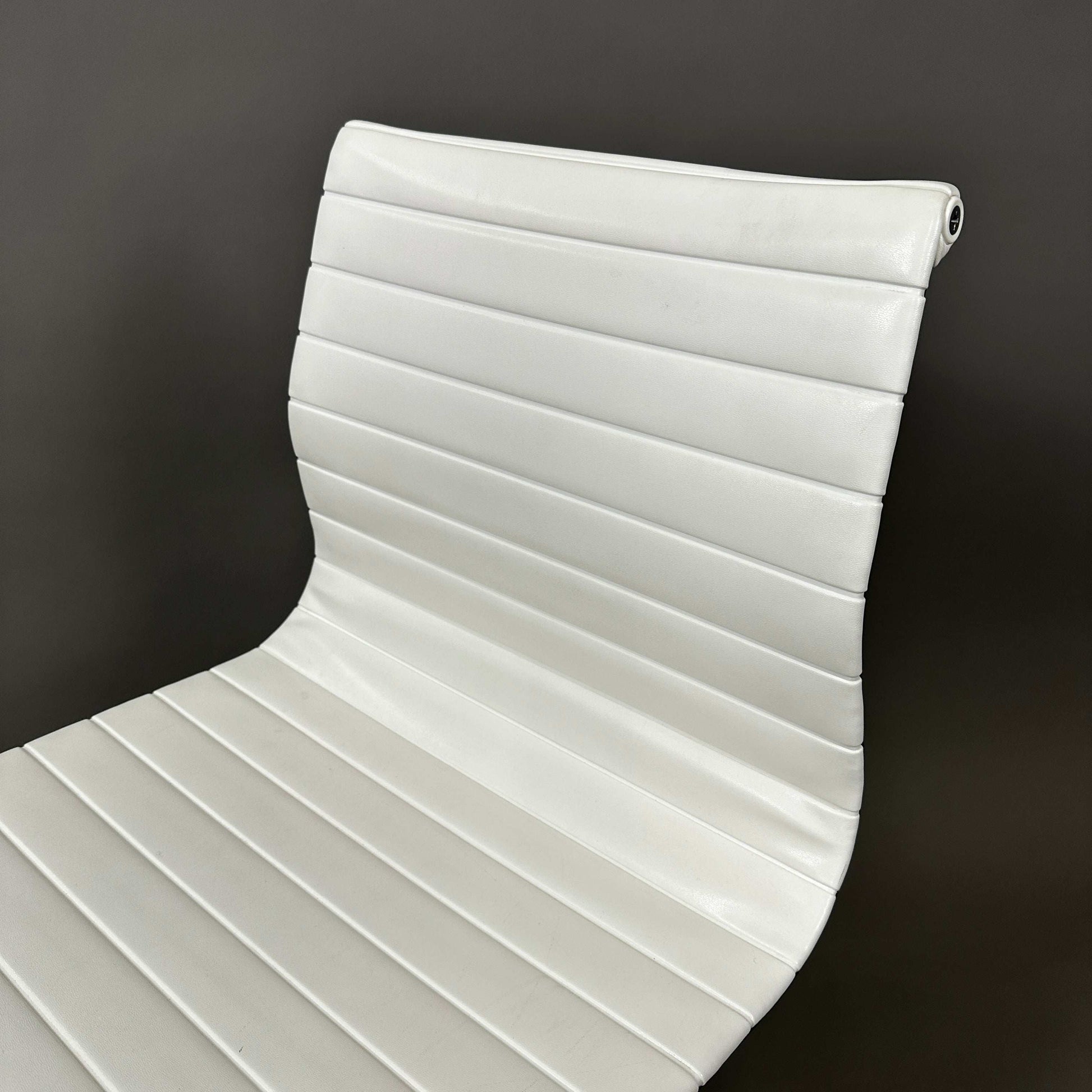 Vitra EA 101 white leather office chair with aluminum frame and no armrests.