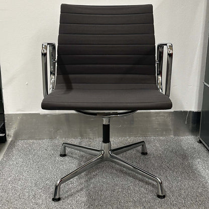 Vitra EA 107 anthracite visitor chair with non-swivel base and sleek chrome arms in minimalist office setting
