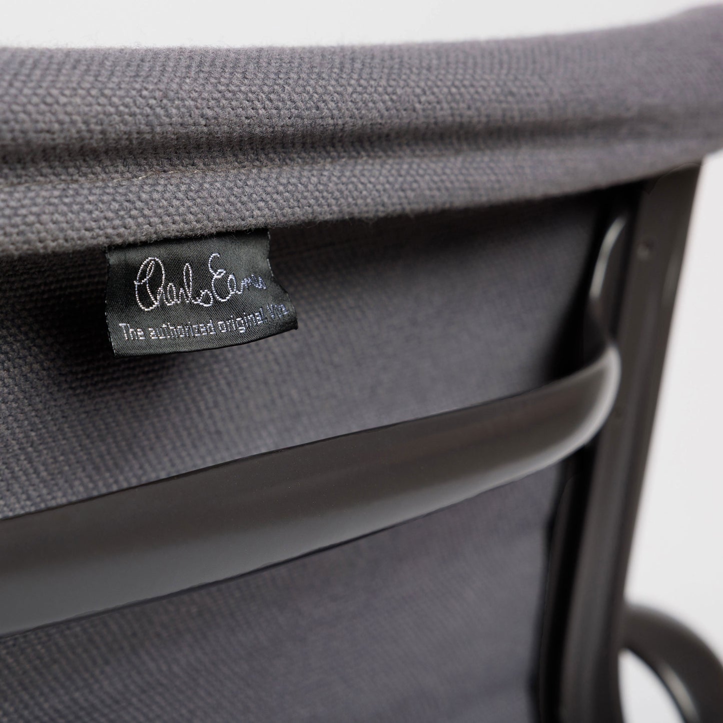 Vitra EA 107 Hopsak dunkelgrau Stuhl mit schwarzem Charles Eames Etikett und dunklem Gestell.
