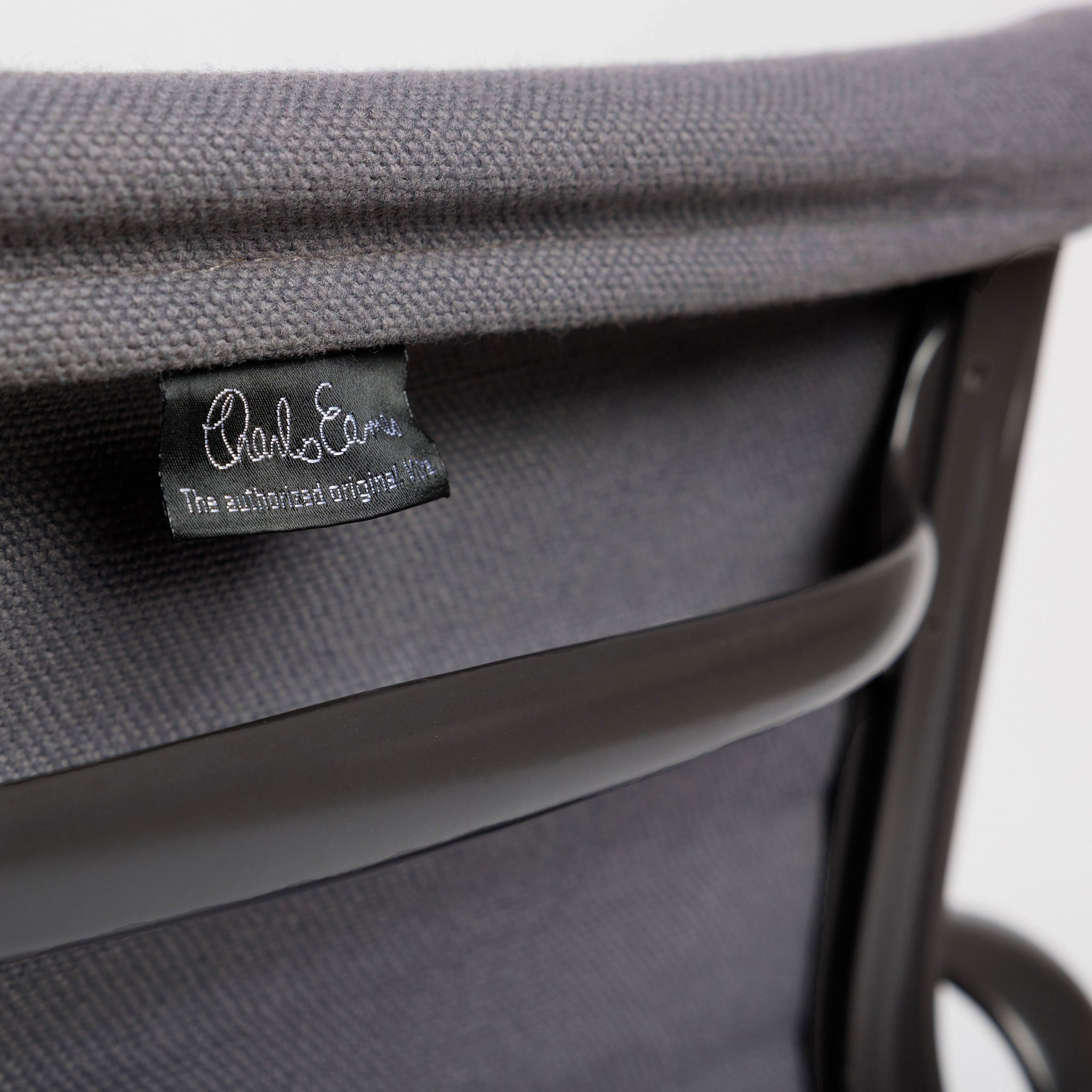 Vitra EA 107 Hopsak dunkelgrau Stuhl mit schwarzem Charles Eames Etikett und dunklem Gestell.