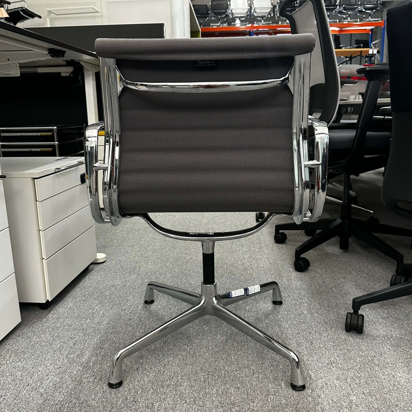 Vitra EA 107 office chair in medium gray hopsak fabric with non-swivel chrome base viewed from the back