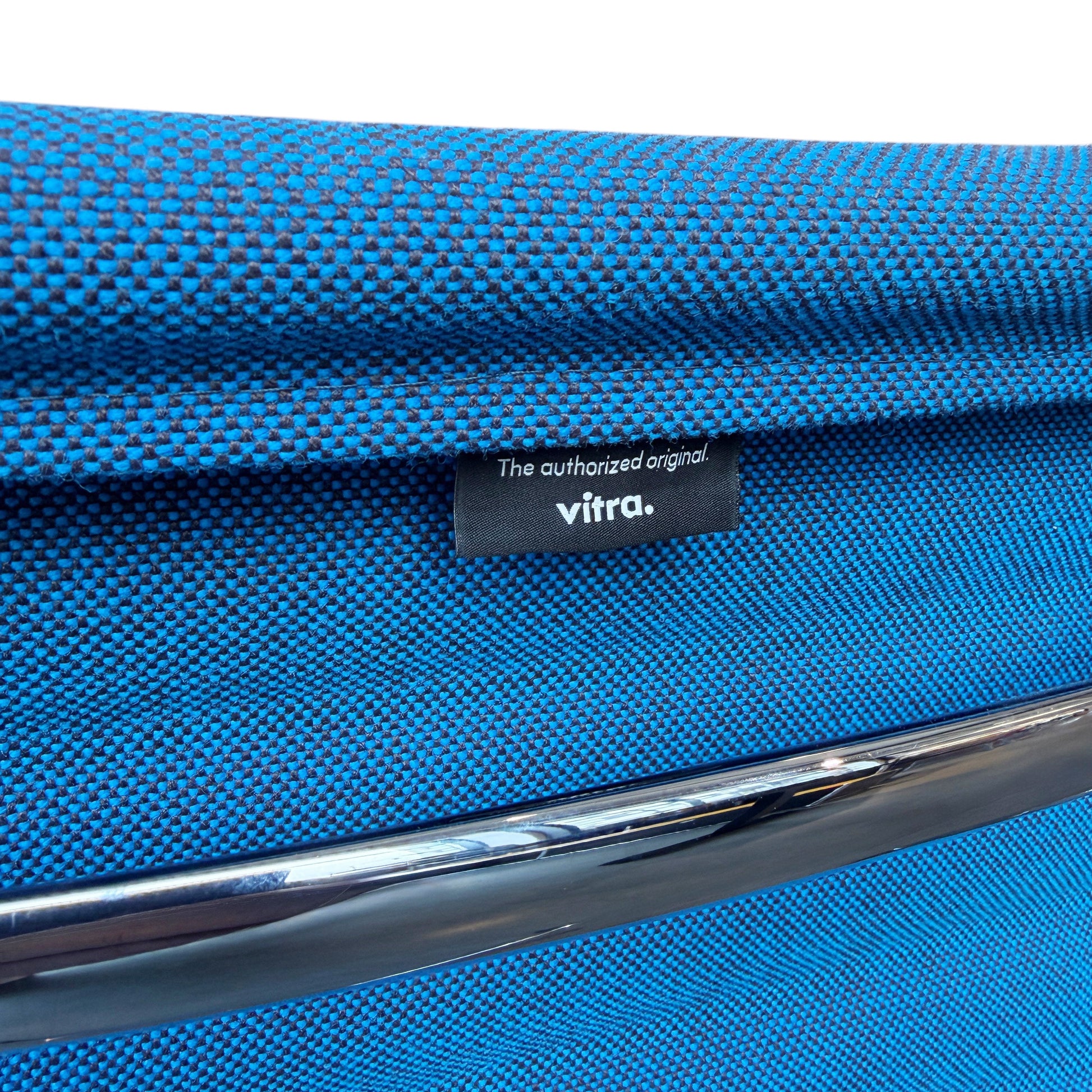 Vitra Eames EA 108 Stuhl mit blauem Hopsak Stoffbezug und Chromgestell, Vitra-Label sichtbar.
