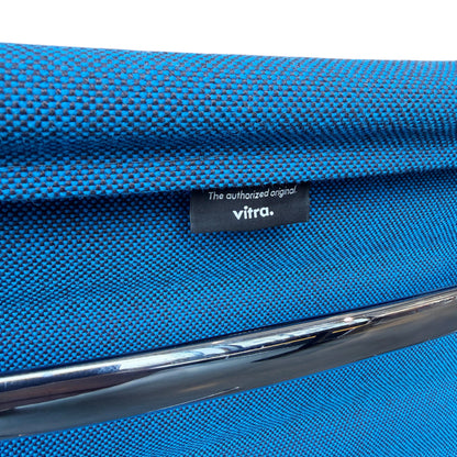 Vitra Eames EA 108 Stuhl mit blauem Hopsak Stoffbezug und Chromgestell, Vitra-Label sichtbar.