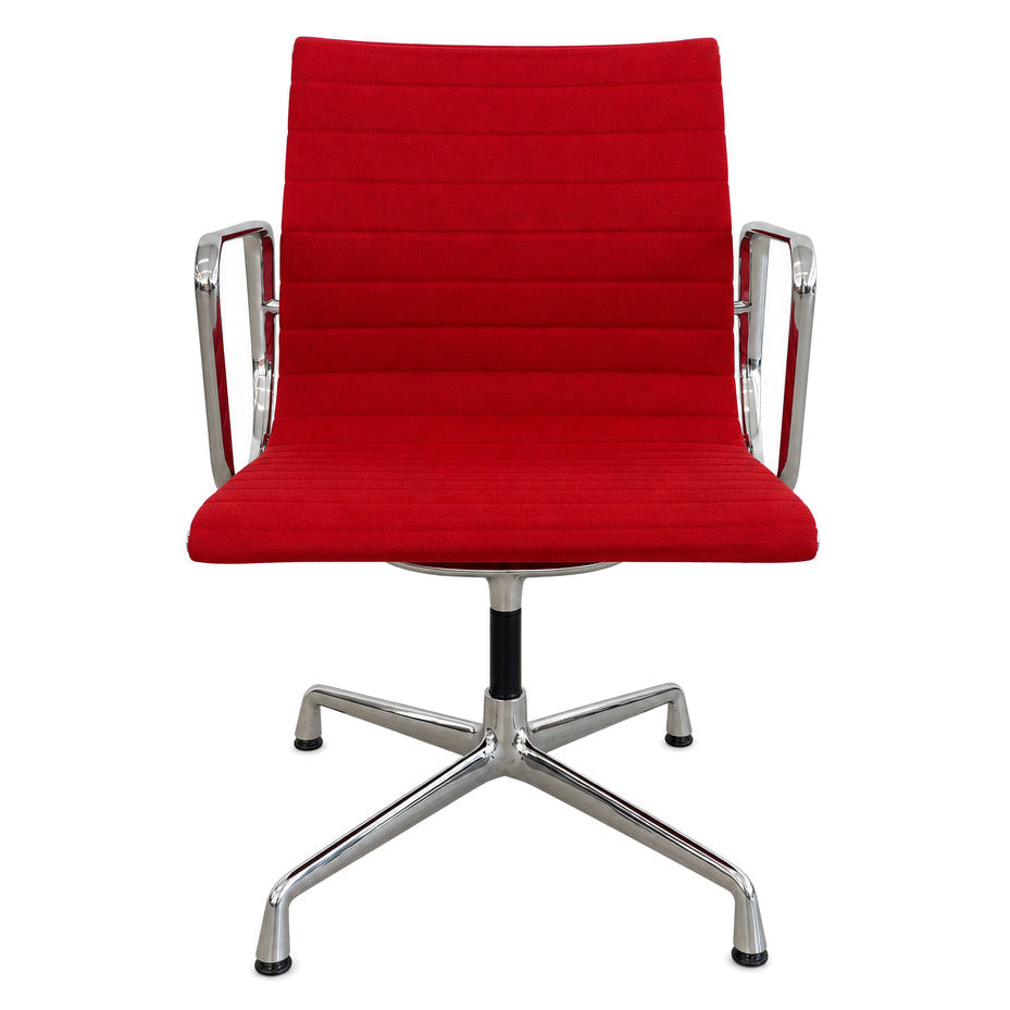 Vitra Eames Alu Chair EA 108 mit rotem Hopsak-Bezug und verchromtem Drehgestell auf weißem Hintergrund.
