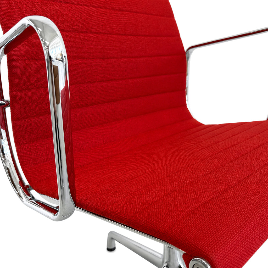 Vitra Eames Alu Chair EA 108 mit rotem Hopsak-Bezug und glänzendem Chromgestell.