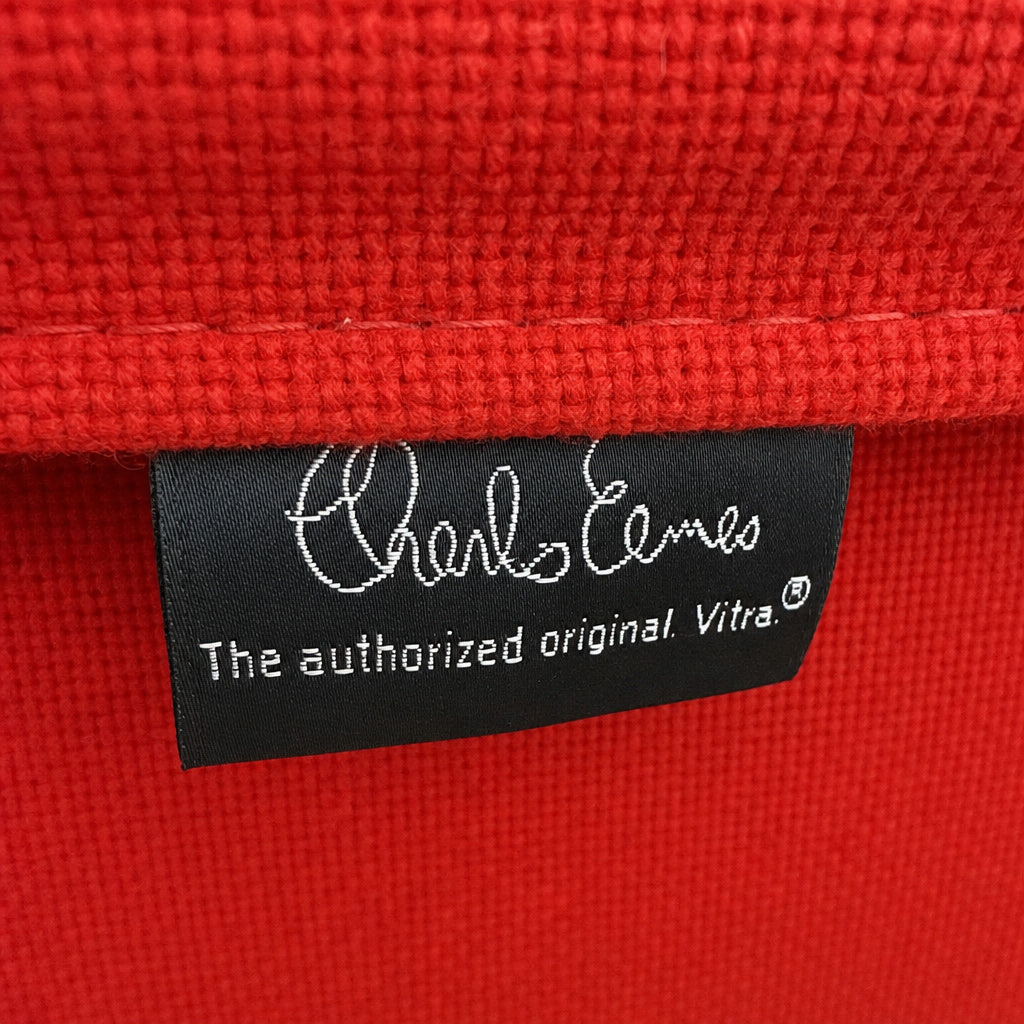 Rotes Hopsak-Gewebe des Vitra Eames Aluminium Chair EA 108 mit eingenähtem Charles Eames Original-Label.