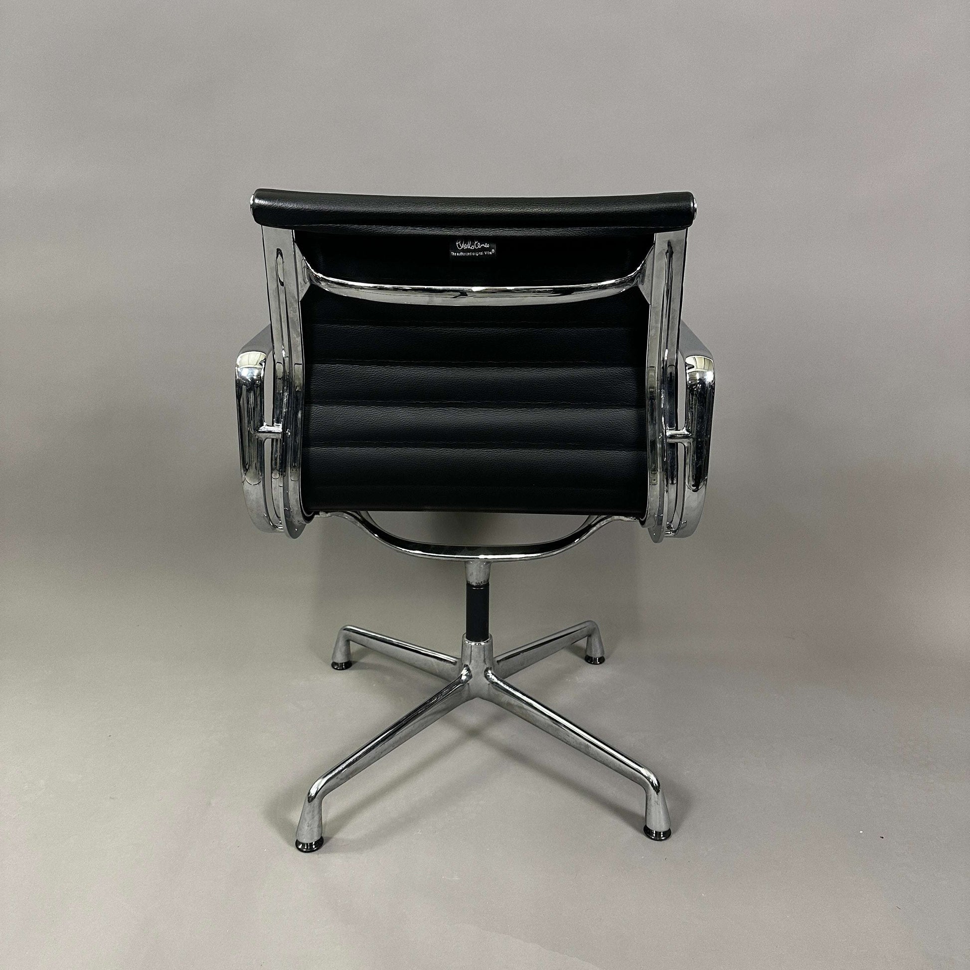 Vitra EA 108 black leather swivel office chair with chrome aluminum frame viewed from back