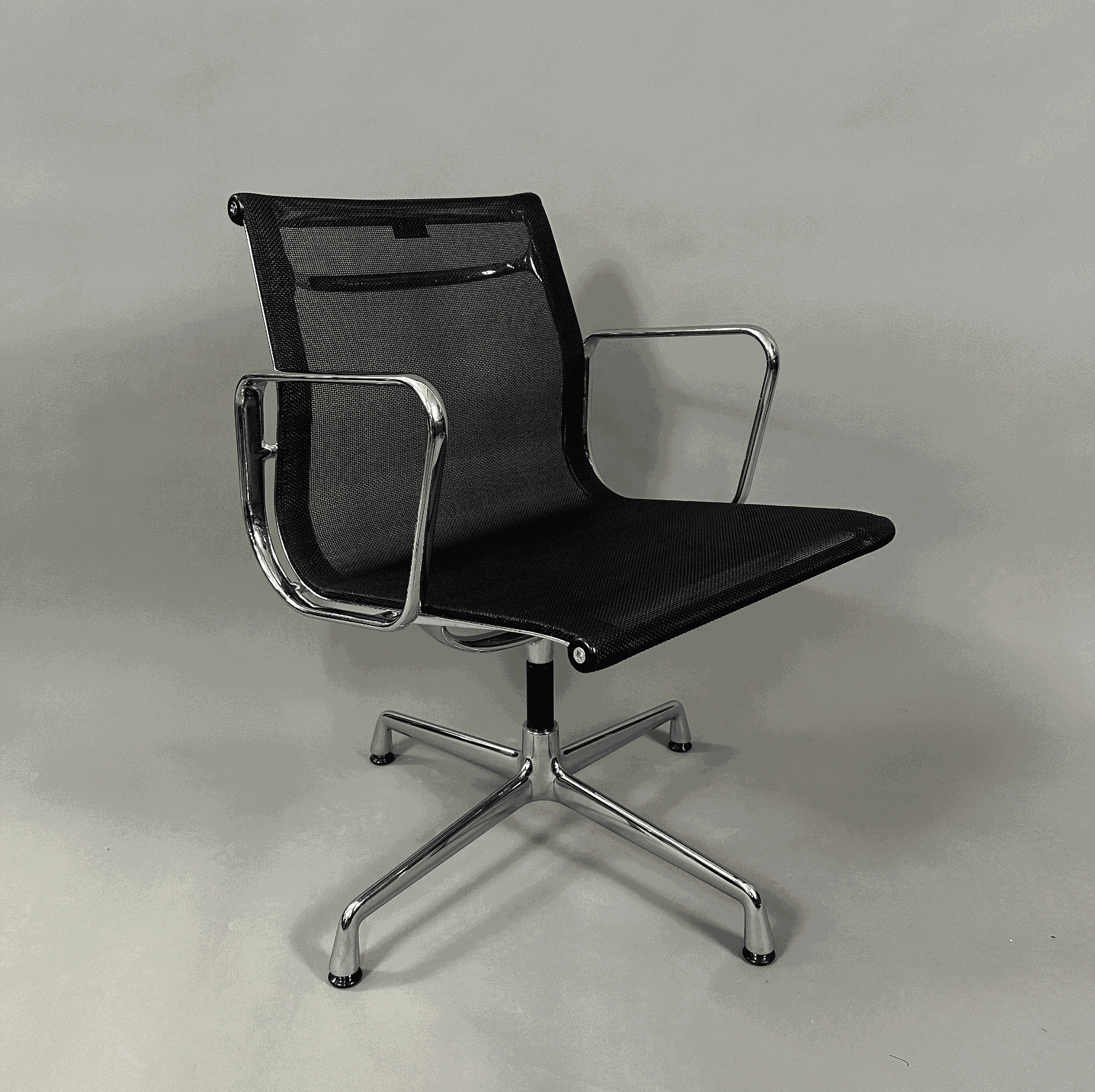 Vitra EA 108 swivel office chair with black mesh seat and chrome frame