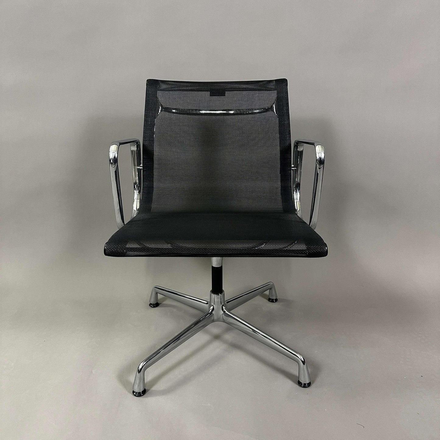 Vitra EA 108 black mesh swivel office chair with chrome frame and armrests
