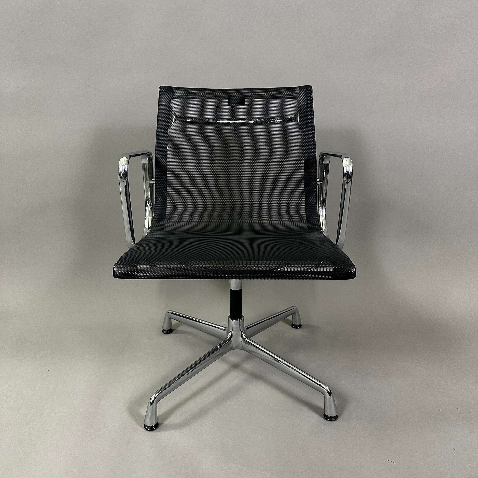 Vitra EA 108 black mesh swivel office chair with chrome frame and armrests