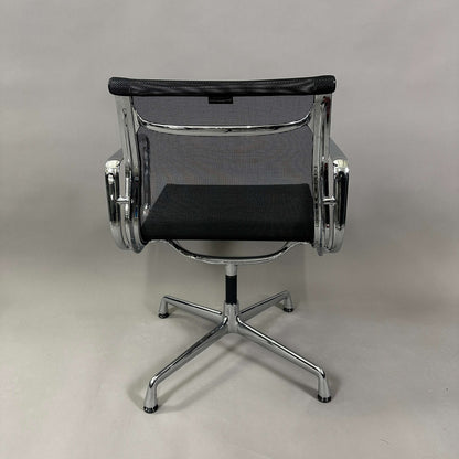 Vitra EA 108 swivel office chair with black mesh and chrome frame viewed from the back