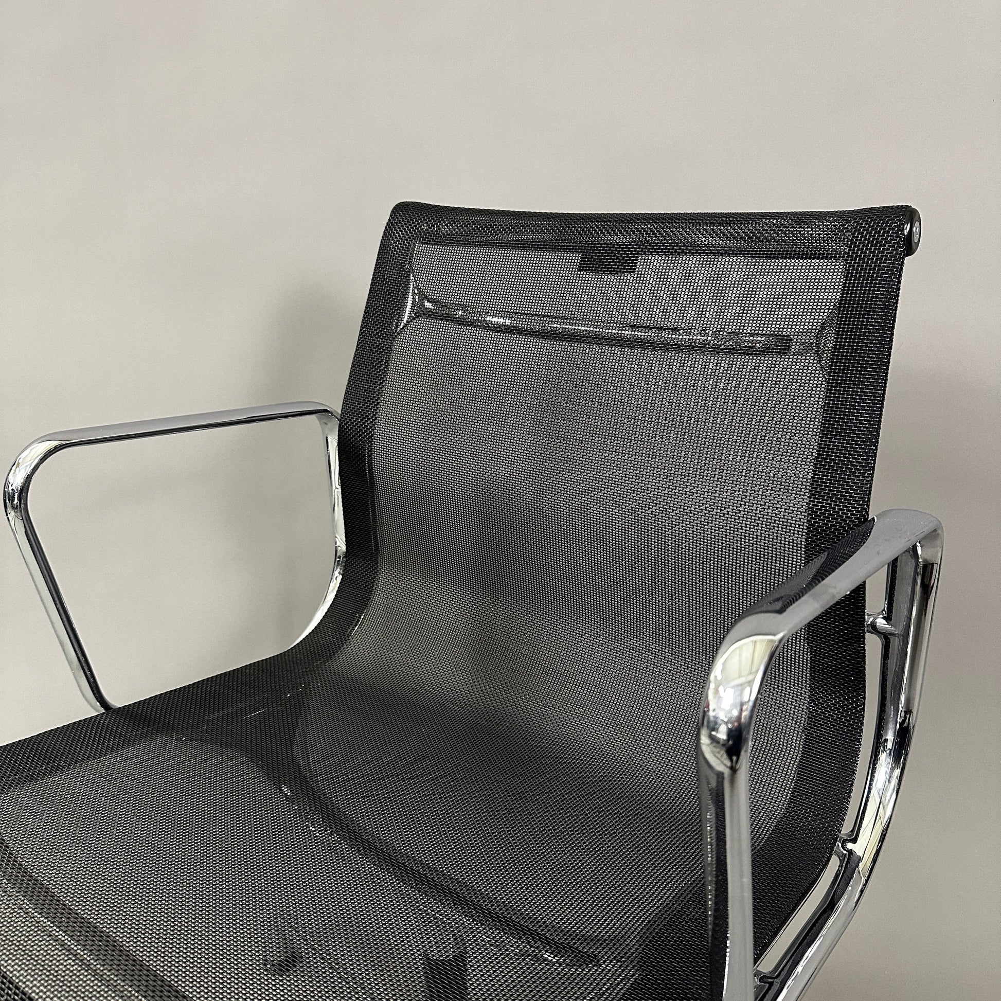 Vitra EA 108 black mesh swivel office chair with chrome frame and armrests