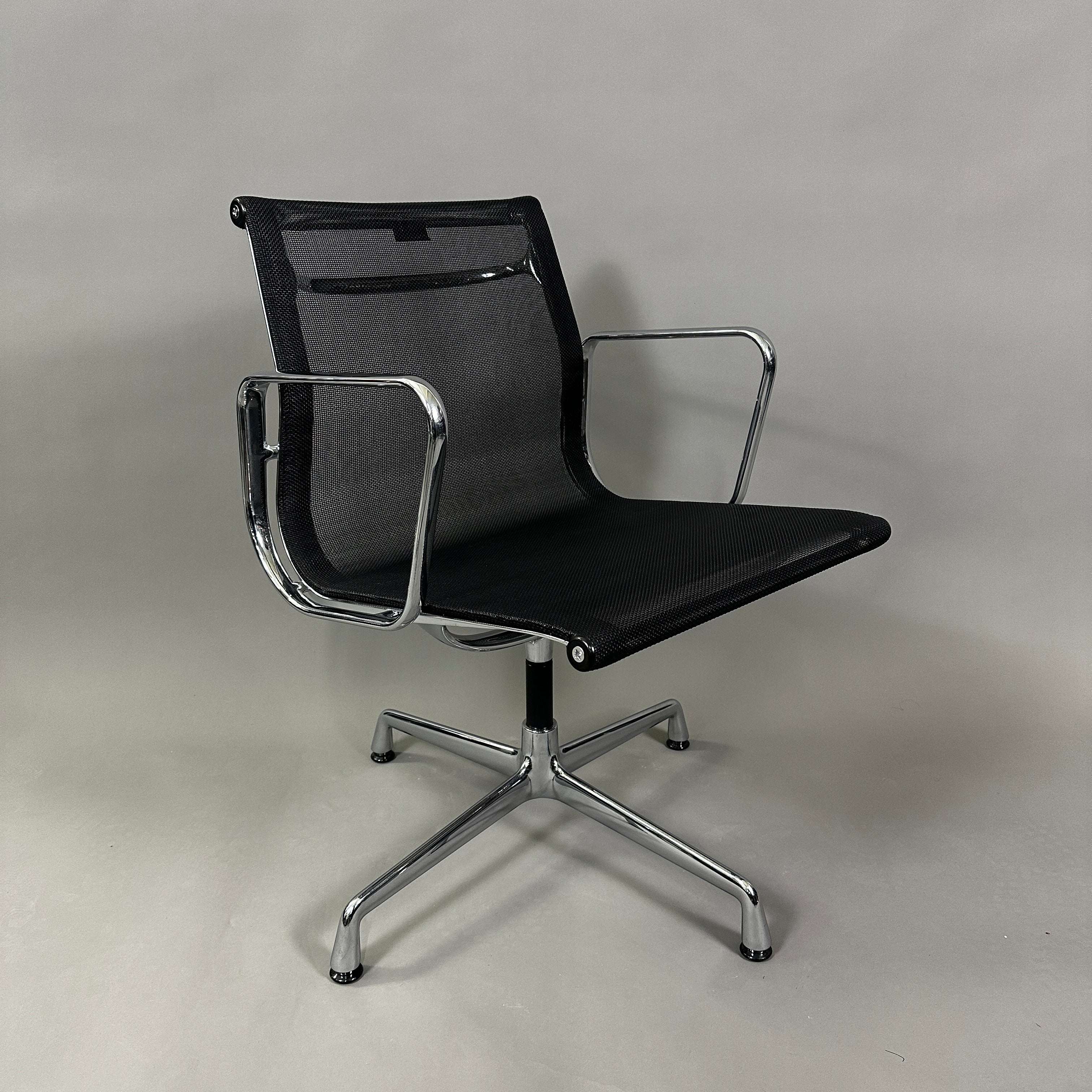 Vitra EA 108 black mesh swivel chair with chrome frame and armrests