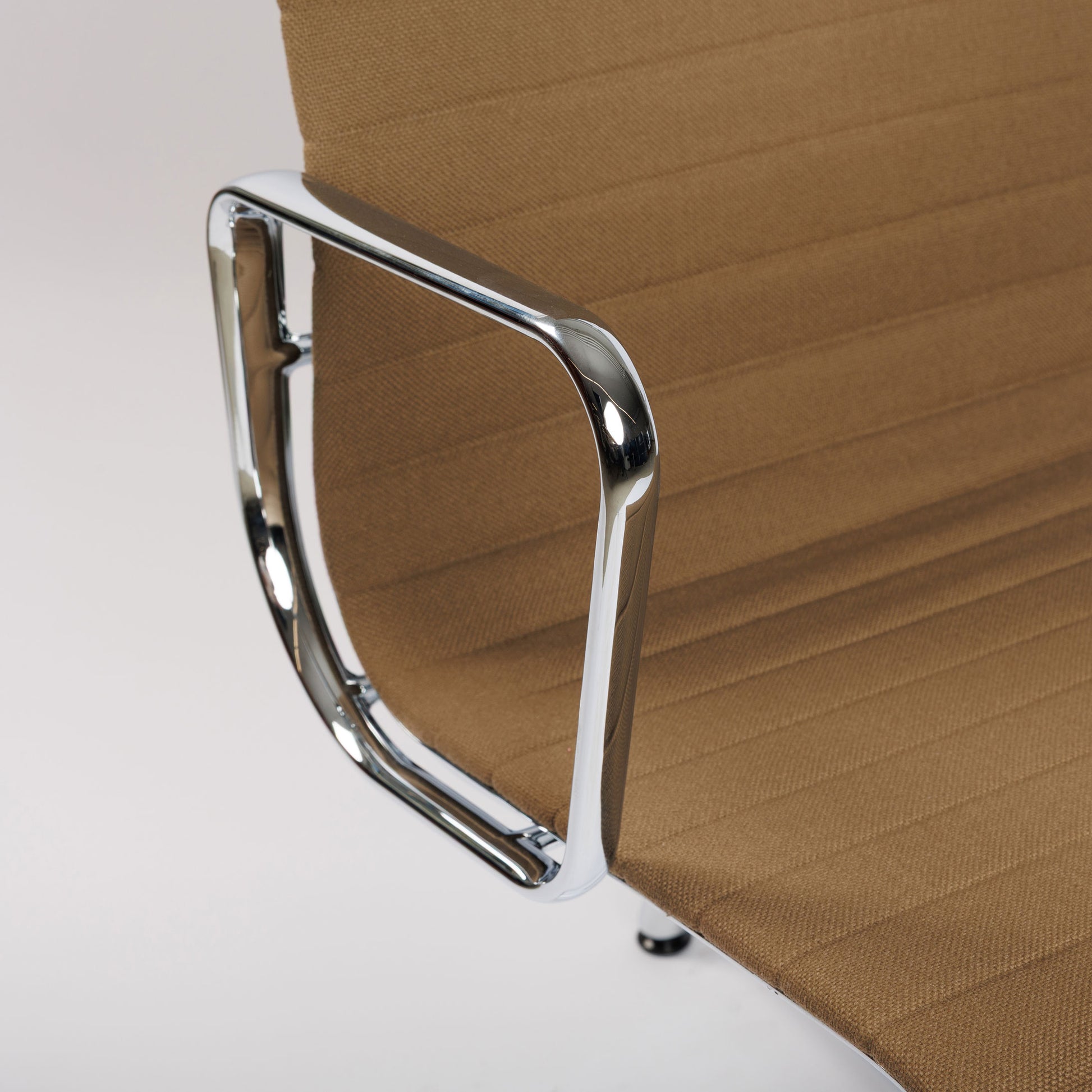 Vitra EA 112 Hopsak chair in brown with chrome armrests and ribbed fabric.