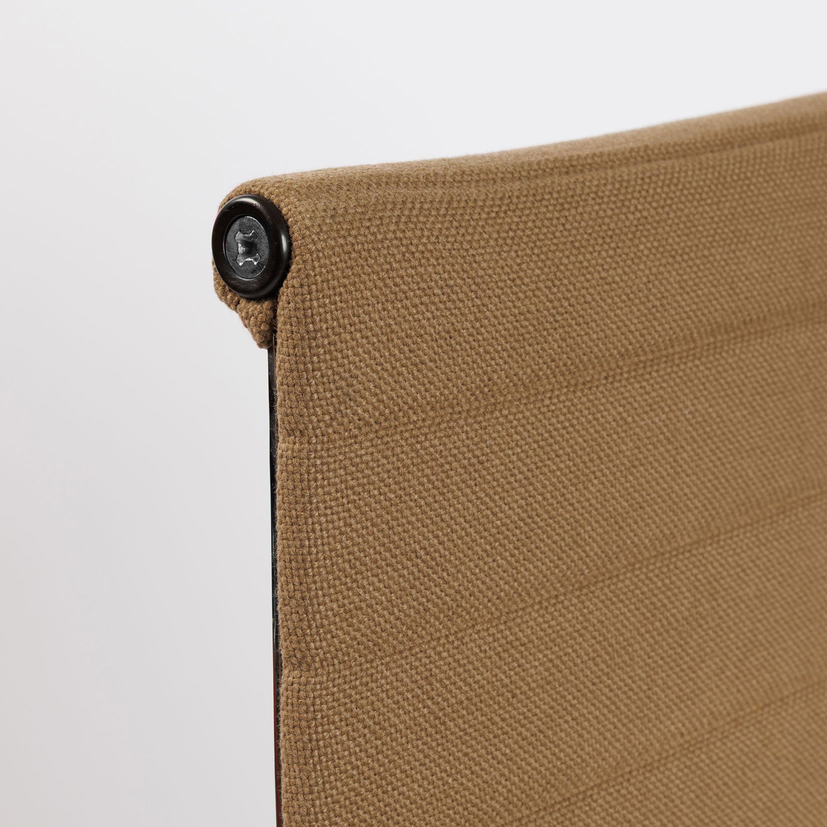 Close-up of a Vitra EA 112 Hopsak chair in brown, showing the textured fabric and a dark screw detail.
