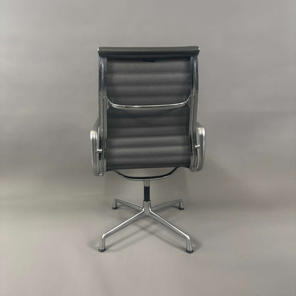 Vitra EA 112 Bürostuhl mit grauem Lederbezug und poliertem Aluminiumgestell von hinten fotografiert