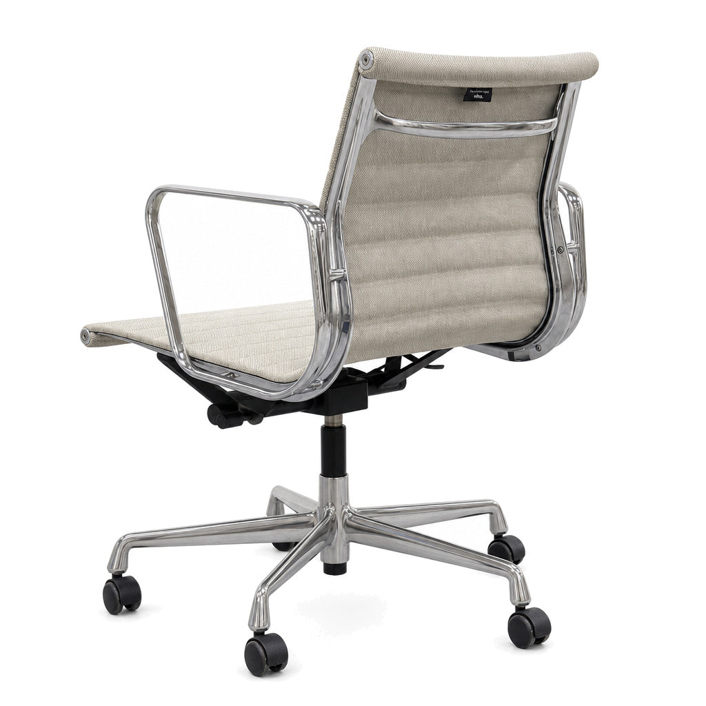 Vitra Eames Alu Chair EA 117 mit beigem Hopsak-Bezug und poliertem Aluminiumgestell auf Rollen, Rückansicht.