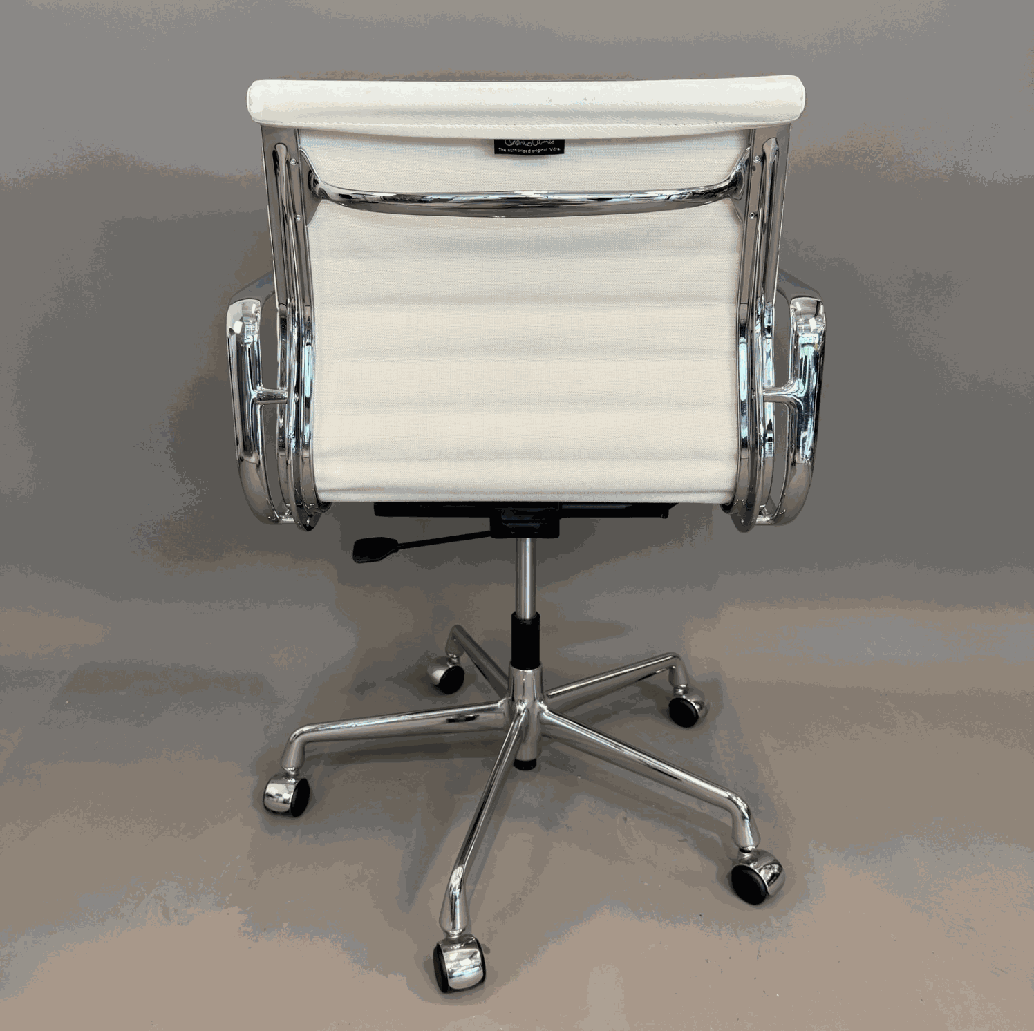 Vitra EA 117 drehbarer Bürostuhl mit weißem Lederbezug und Chromgestell von hinten sichtbar