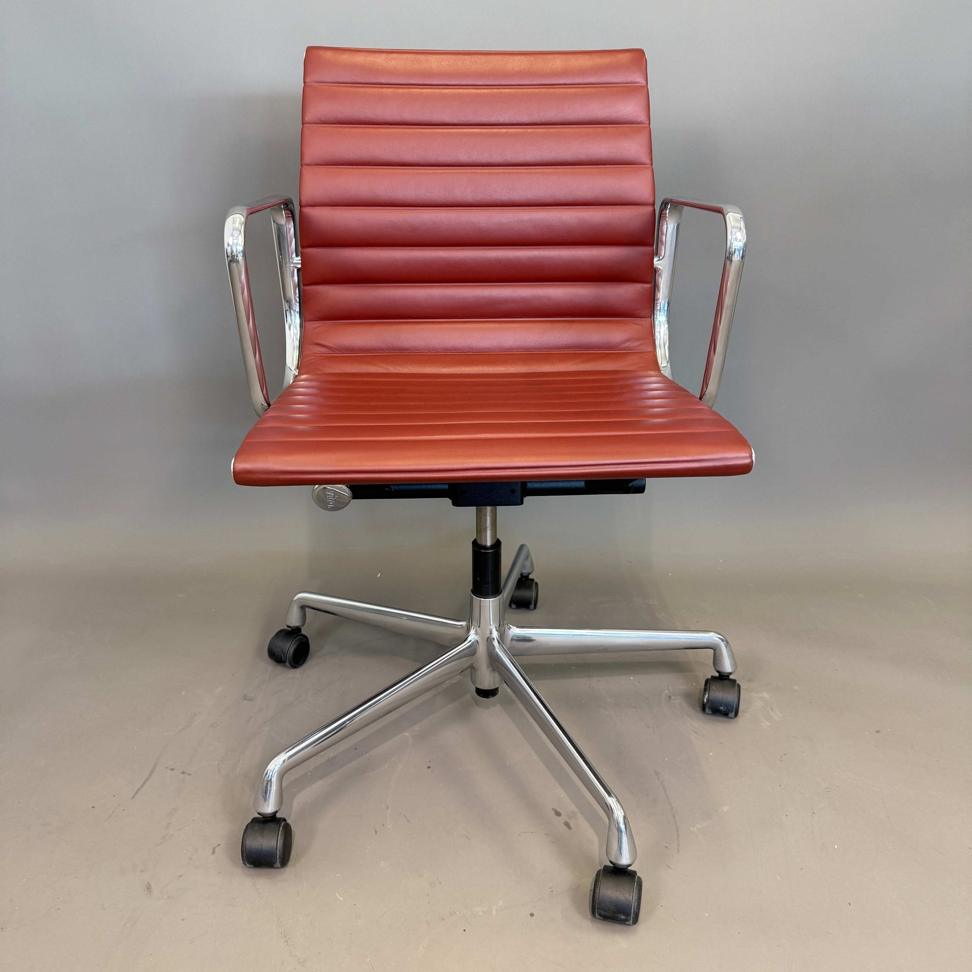 Vitra EA 117 Bürostuhl aus terracotta Premium Leder mit poliertem Aluminiumgestell und drehbarer Sitzfläche.