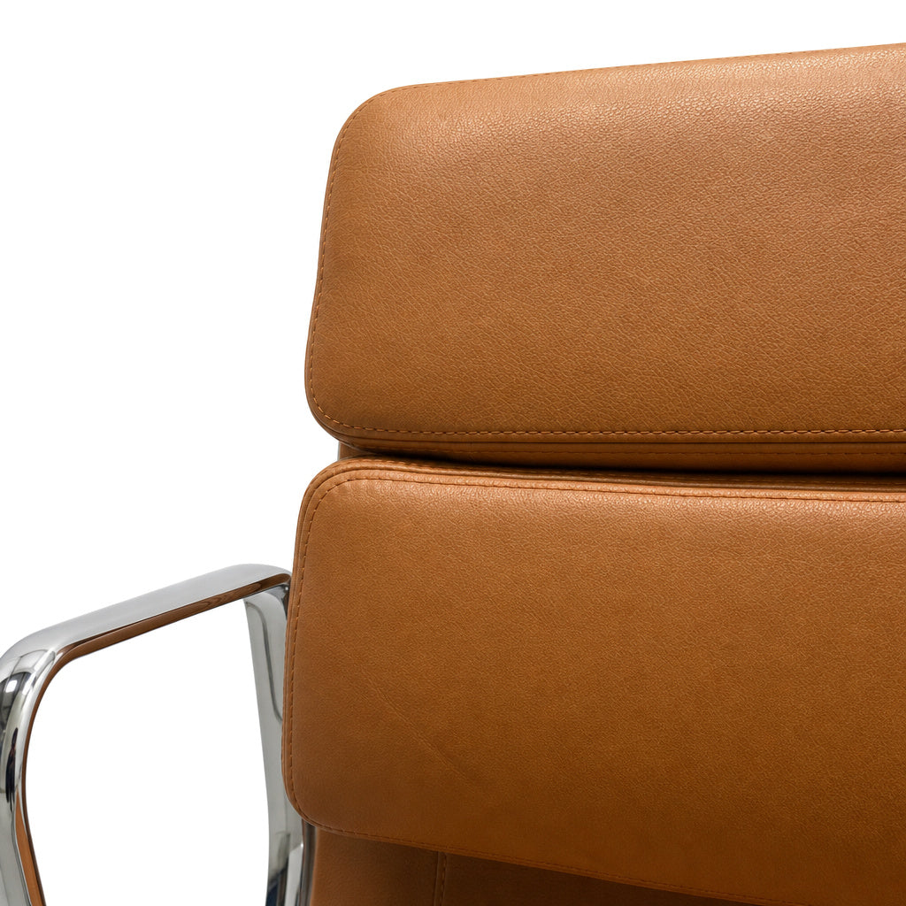 Vitra Eames EA 208 Bürostuhl mit cognacfarbenem Premium-Lederpolster und glänzendem Chromrahmen.